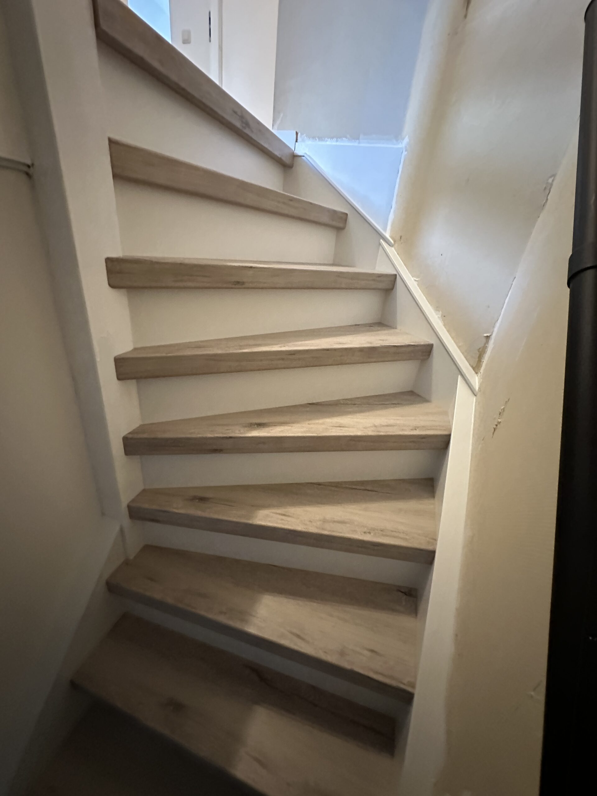 Voor deze klant in Zoetermeer hebben wij een dichte trap mogen renoveren. De klant koos voor het Forrest decor voor de treden met witte stootborden. De laatste trede is mooi afgewerkt met een champagnekleurig aluminium profiel. De wangen van de trap hebben we ook mogen renoveren omdat deze volledig onder de lijmresten van het tapijt zaten. Deze hebben we een friswitte kleur gegeven, evenals de afdekkappen.