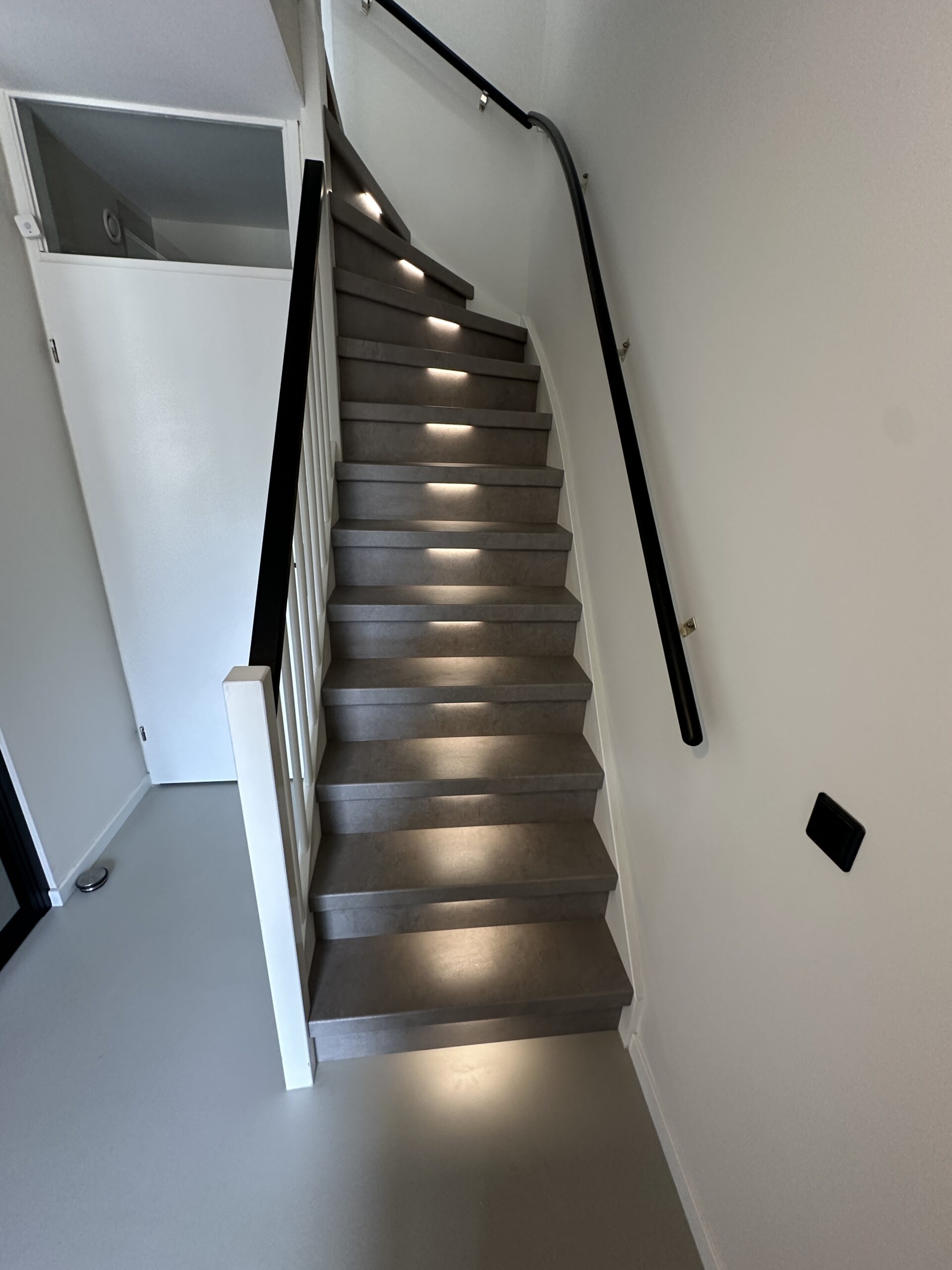 Voor deze klant in Den Haag hebben we een dichte trap gerenoveerd incl. LED-verlichting. De klant koos voor het Loft decor met bijpassende stootborden. De laatste trede is mooi afgewerkt met een zwart aluminium profiel. De LED-verlichting gaat automatisch aan indien je je in de buurt van de trap bevindt, dit door draadloze bewegingssensoren van Philips HUE. Ook kan de klant door middel van een app de kleurtemperatuur en kleursterkte bepalen.