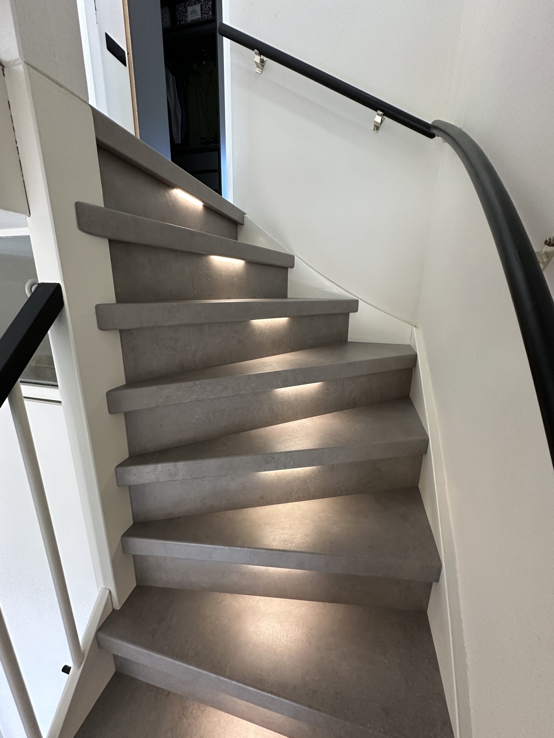 Voor deze klant in Den Haag hebben we een dichte trap gerenoveerd incl. LED-verlichting. De klant koos voor het Loft decor met bijpassende stootborden. De laatste trede is mooi afgewerkt met een zwart aluminium profiel. De LED-verlichting gaat automatisch aan indien je je in de buurt van de trap bevindt, dit door draadloze bewegingssensoren van Philips HUE. Ook kan de klant door middel van een app de kleurtemperatuur en kleursterkte bepalen.