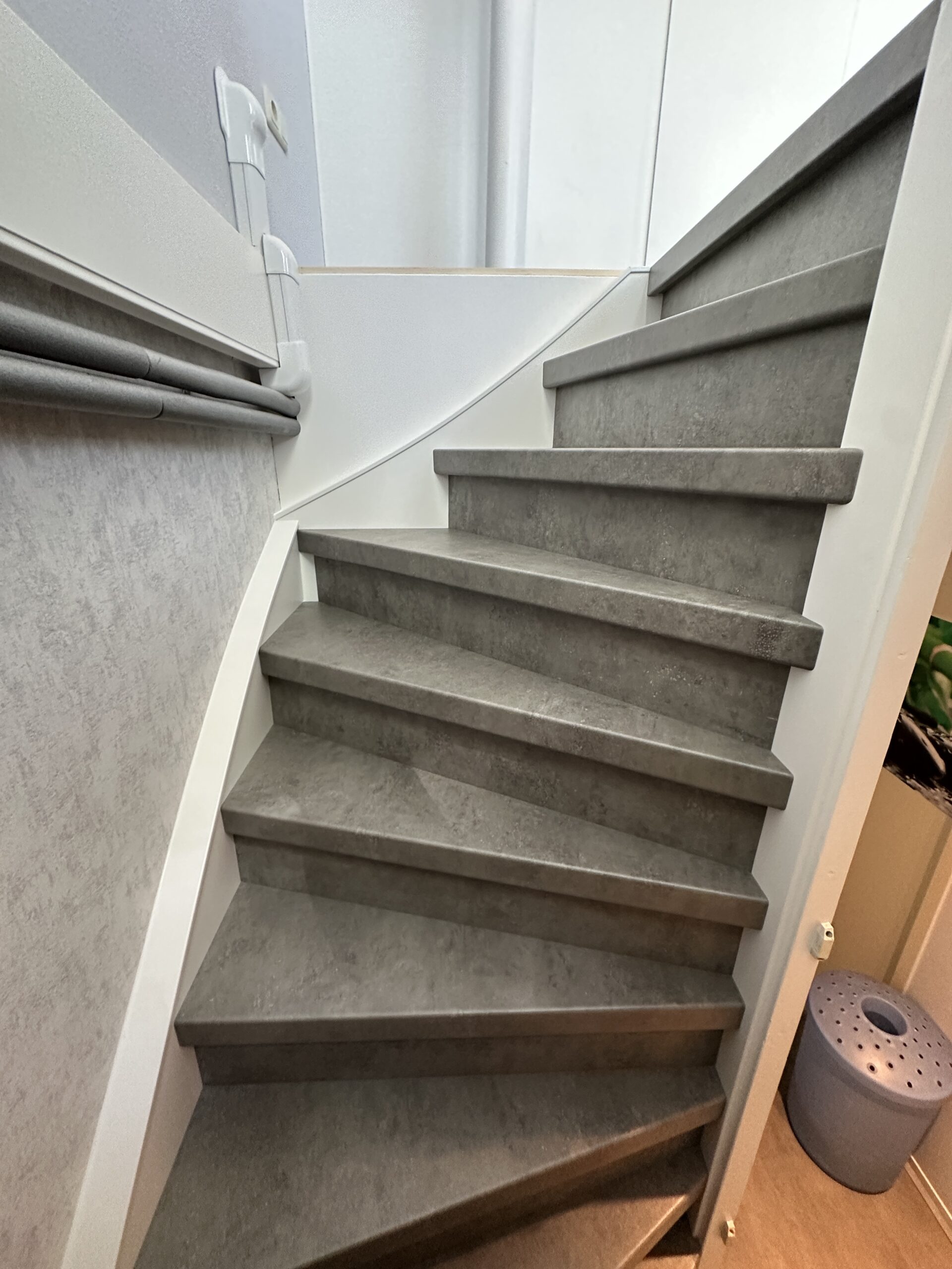 Voor deze klant in Zoetermeer hadden we vorig jaar al de trap beneden gerenoveerd, nu wilde de klant graag ook de dichte trap boven laten renoveren. De klant koos voor zowel de treden als de stootborden voor het Beton-decor. De laatste trede is mooi afgewerkt met een zilver aluminium profiel. De wangen van de trap hebben we ook mogen renoveren omdat deze volledig onder de lijmresten van het tapijt zaten. Deze hebben we een friswitte kleur gegeven, evenals de afdekkappen.