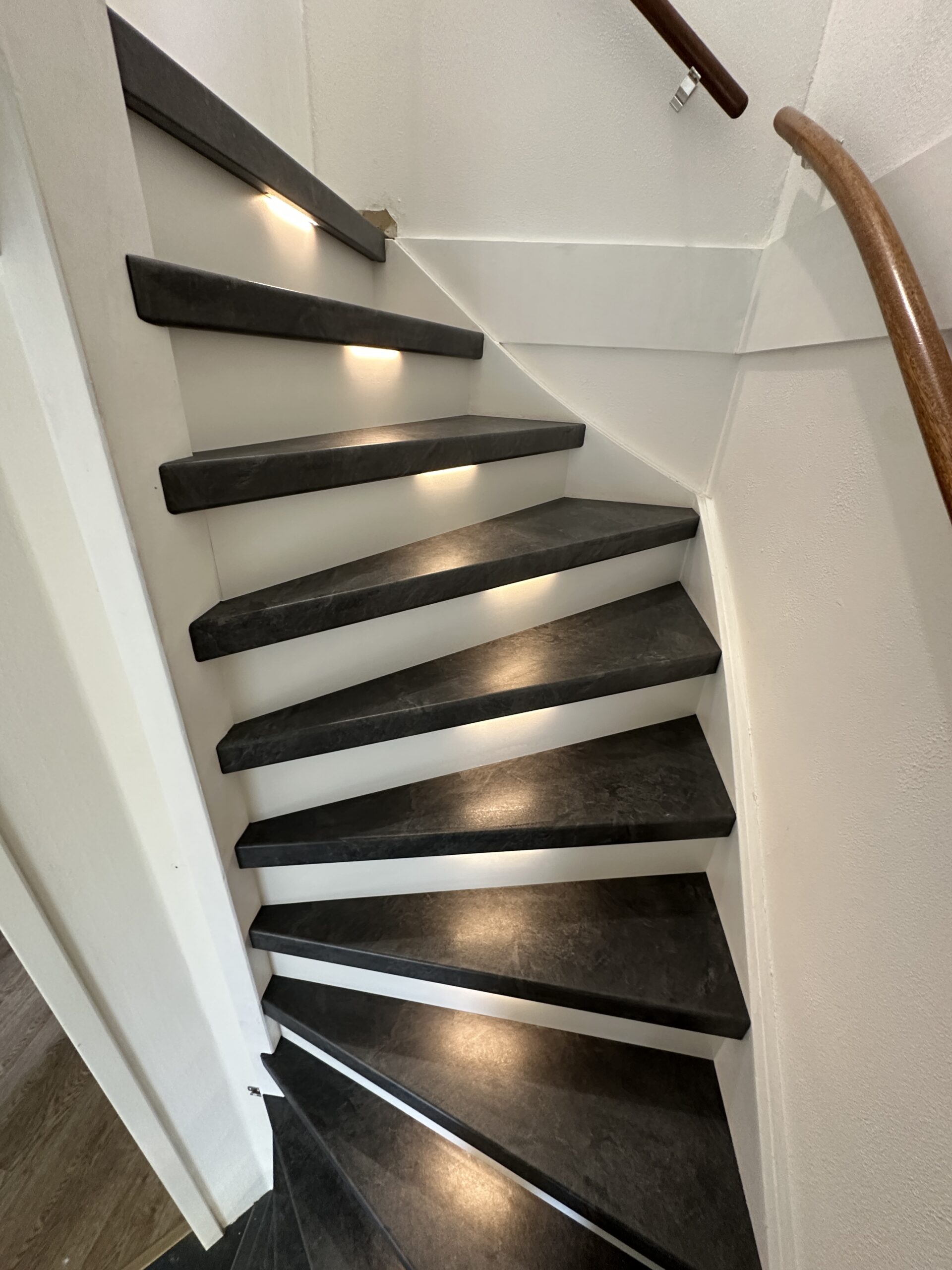 Voor deze klant in Leidschendam hebben we een dichte trap gerenoveerd incl. LED-verlichting. De klant koos voor het Mustang decor met witte stootborden. De laatste trede is mooi afgewerkt met een zwart aluminium profiel. De LED-verlichting gaat automatisch aan indien je je in de buurt van de trap bevindt, dit door draadloze bewegingssensoren. Ook kan de klant door middel van een app de kleurtemperatuur en kleursterkte bepalen.