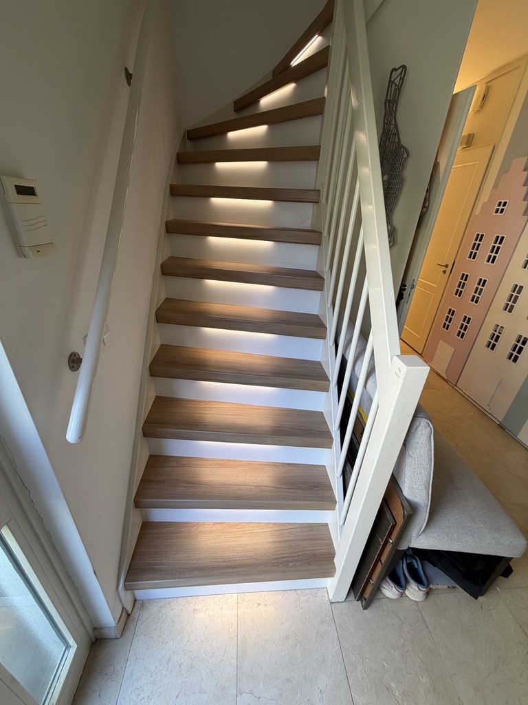 Traprenovatie eiken decor met witte stootborden en led verlichting