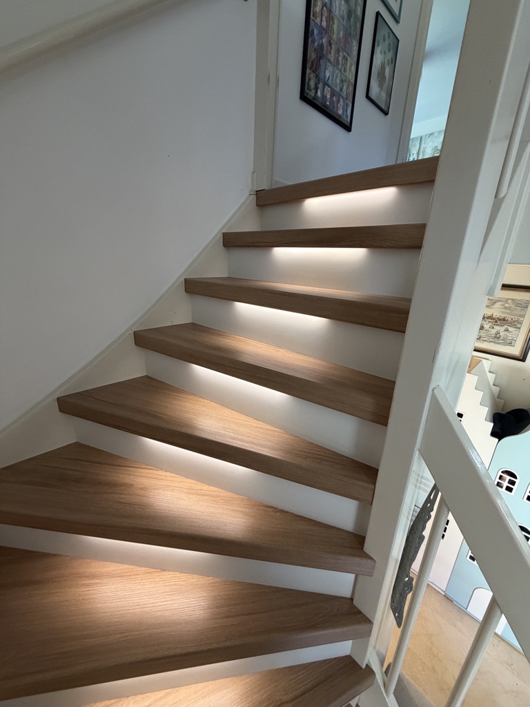 Traprenovatie eiken decor met witte stootborden en led verlichting